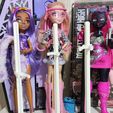 photo_2025-09-18_14-13-47.jpg Suporte para bonecas Monster High G1, G2, G3 - Suportes para fêmeas e machos, opção de tamanho grande, impressão multicolorida