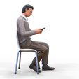 ManSitiing_1.12.111.jpg A Man sitting on a chair with smartphone