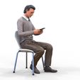 ManSitiing_1.12.121.jpg A Man sitting on a chair with smartphone