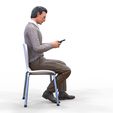 ManSitiing_1.12.106.jpg A Man sitting on a chair with smartphone
