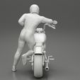 3DG-0011.jpg Motorbiker standing pushing his motorbike