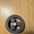 Photo-of-3D-printed-fidget-spinner-underside-showing-herringbone-ring-and-planet-gears-with-silver-h.jpg Fidget spinner multisensoriale con ingranaggi planetari ORBIT. Giocattolo OpenSCAD parametrico stampato in loco con numeri in braille, cappucci celesti tattili e feedback acustico