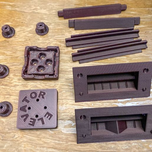 FW-ELV-Fidget-Elevator-20-Assembly-01-all-printed-parts-on-table-IMG_7099-scaled.jpg Fidget Elevator: a mechanical curio bizarrely without compliant parts