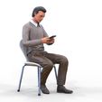ManSitiing_1.12.126.jpg A Man sitting on a chair with smartphone