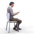 ManSitiing_1.12.101.jpg A Man sitting on a chair with smartphone