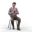 ManSitiing_1.12.141.jpg A Man sitting on a chair with smartphone