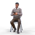 ManSitiing_1.12.151.jpg A Man sitting on a chair with smartphone