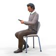 ManSitiing_1.12.26.jpg A Man sitting on a chair with smartphone