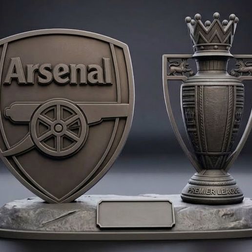 The standard Arsenal club crest and the Premier League trophy on the desk with a base