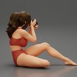 3DG-0004.jpg Woman photographer in bikini sitting and holding a camera